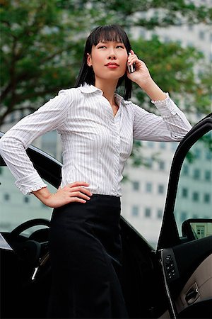 Businesswoman using mobile phone, hand on hip, leaning on car door Stock Photo - Premium Royalty-Free, Code: 656-01772217