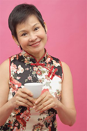 Mature woman cheongsam, holding Chinese tea cup Stock Photo - Premium Royalty-Free, Code: 656-01772308