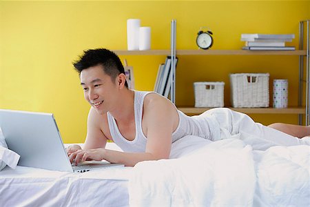 simsearch:656-01773560,k - Man lying on bed in bedroom, using laptop Stock Photo - Premium Royalty-Free, Code: 656-01772484