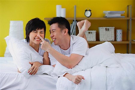 simsearch:656-01773586,k - Couple lying on bed, man touching woman's nose Stock Photo - Premium Royalty-Free, Code: 656-01772489