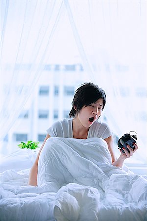 simsearch:656-01773560,k - Woman in bed, looking at alarm clock, mouth open Stock Photo - Premium Royalty-Free, Code: 656-01772498