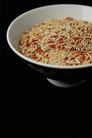 simsearch:656-01772085,k - Bowl of uncooked rice against black background Stock Photo - Premium Royalty-Free, Code: 656-01772644