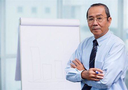 simsearch:656-01772656,k - Businessman standing in front of flip board, portrait Stock Photo - Premium Royalty-Free, Code: 656-01772666