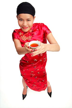 Young woman in cheongsam holding cup of tea Stock Photo - Premium Royalty-Free, Code: 656-01772732