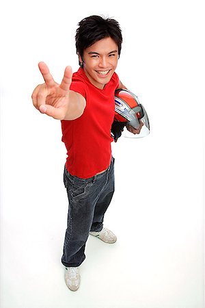 peace symbol - Young man with motorcycle helmet, making peace sign Stock Photo - Premium Royalty-Free, Code: 656-01772748