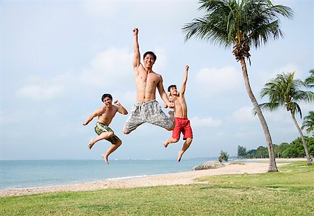 simsearch:656-01772853,k - Three men jumping in air, looking at camera Fotografie stock - Premium Royalty-Free, Codice: 656-01772828
