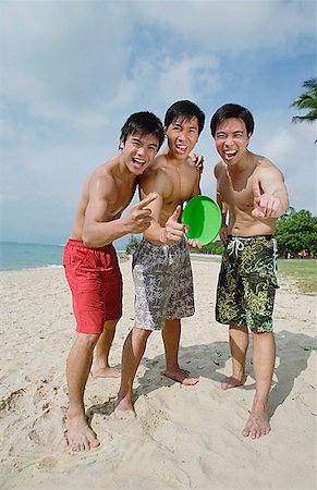 simsearch:656-01772853,k - Three men on beach, standing side by side, making hand sign Fotografie stock - Premium Royalty-Free, Codice: 656-01772842