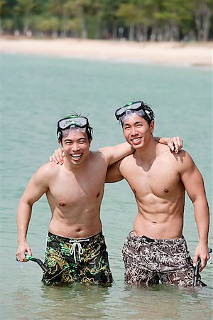 simsearch:656-01772853,k - Two men standing in sea, arms around each other Fotografie stock - Premium Royalty-Free, Codice: 656-01772859