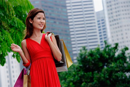 simsearch:656-01771655,k - Woman in red dress carrying shopping bags, city location Foto de stock - Sin royalties Premium, Código: 656-01772997