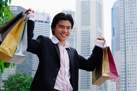 Man carrying shopping bags, smiling at camera Stock Photo - Premium Royalty-Free, Code: 656-01773003