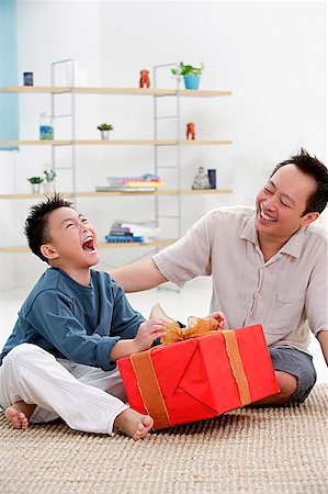 person opening shirt - Father and son at home, boy opening gift, looking up Stock Photo - Premium Royalty-Free, Code: 656-01773045