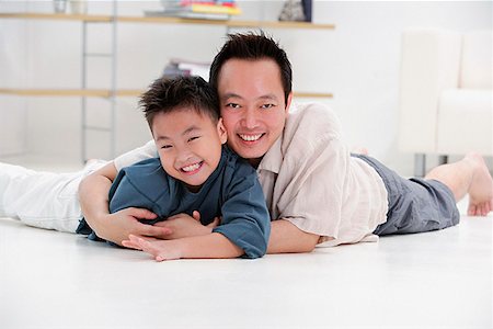 simsearch:656-01768177,k - Father and son lying on floor, embracing, portrait Stock Photo - Premium Royalty-Free, Code: 656-01773049