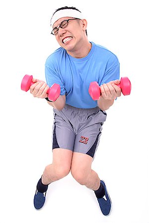 eyes closed portrait of asian man - Man sitting on stool, lifting weights, grimacing Stock Photo - Premium Royalty-Free, Code: 656-01773070