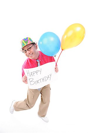 Man with party hat holding balloons and a sign Stock Photo - Premium Royalty-Free, Code: 656-01773094