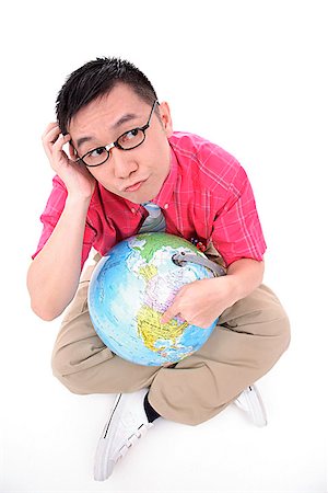 Man sitting on floor, holding globe, thinking Stock Photo - Premium Royalty-Free, Code: 656-01773099