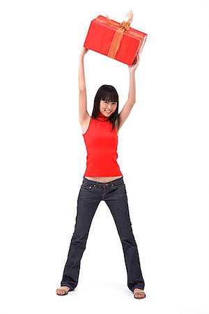 Young woman holding big red gift box over her head Stock Photo - Premium Royalty-Free, Code: 656-01773158