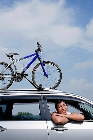 simsearch:656-01773782,k - Homme assis dans la voiture, en se penchant par fenêtre, vélo sur le toit de la voiture Photographie de stock - Premium Libres de Droits, Code: 656-01773221
