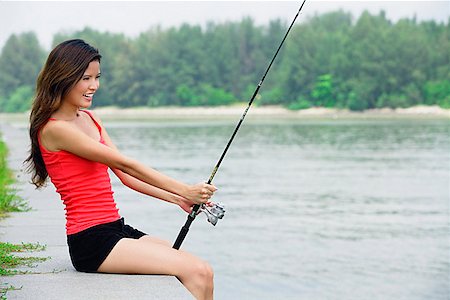 Woman holding fishing poles alone Stock Photos - Page 1 : Masterfile