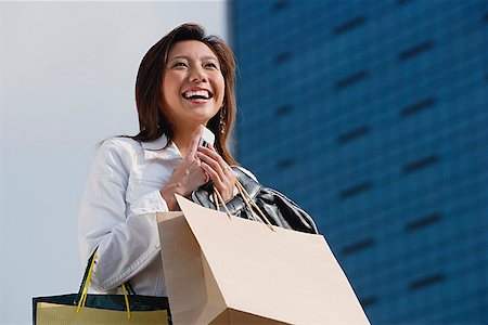 simsearch:656-01771655,k - Woman carrying shopping bags, holding mobile phone, smiling Foto de stock - Sin royalties Premium, Código: 656-01773313
