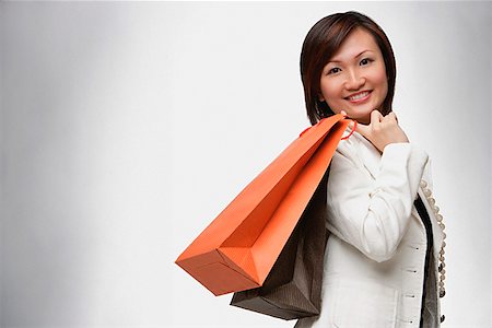 simsearch:656-01771655,k - Businesswoman carrying shopping bags over shoulder, smiling Foto de stock - Sin royalties Premium, Código: 656-01773518