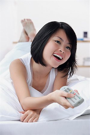 Junge Frau mit TV-Fernbedienung, Lächeln Stockbilder - Premium RF Lizenzfrei, Bildnummer: 656-01773550
