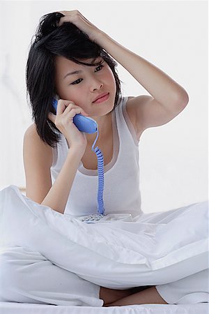 simsearch:656-01773928,k - Young woman using telephone, hand on head Foto de stock - Royalty Free Premium, Número: 656-01773560