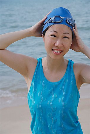 Mature woman wearing swim cap and goggles, standing by beach Foto de stock - Sin royalties Premium, Código: 656-01773599