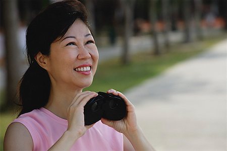 Mature woman holding binoculars, looking away Stock Photo - Premium Royalty-Free, Code: 656-01773611