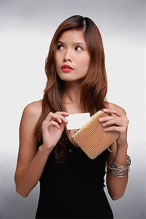 financial highlights - Woman in black top, putting credit card into purse Stock Photo - Premium Royalty-Free, Code: 656-01773652