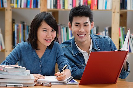 sage - Couple étudiant en bibliothèque, souriant à la caméra Photographie de stock - Premium Libres de Droits, Code: 656-01773826