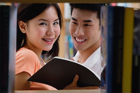 Couple in library, woman looking at camera Stock Photo - Premium Royalty-Free, Code: 656-01773823