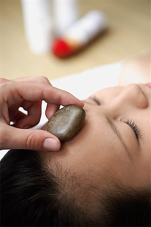 simsearch:685-02940844,k - Young woman in spa, massage stone being placed on her forehead Fotografie stock - Premium Royalty-Free, Codice: 656-01773842