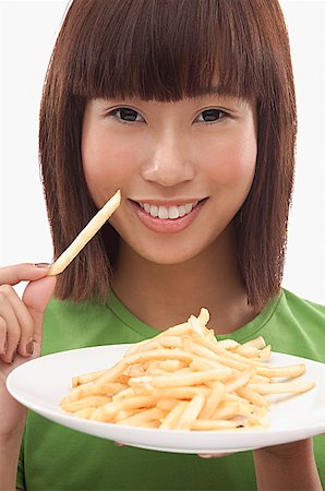 french fry smile - Young woman holding a plate of French fries Stock Photo - Premium Royalty-Free, Code: 656-01773884