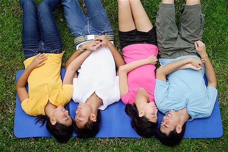 Young adults in park, lying on mat Stock Photo - Premium Royalty-Free, Code: 656-01773971