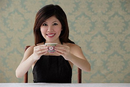 Young woman holding teacup with both hands Stock Photo - Premium Royalty-Free, Code: 656-01828791