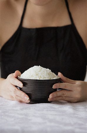 Young woman holding bowl of rice with both hands Stock Photo - Premium Royalty-Free, Code: 656-01828879