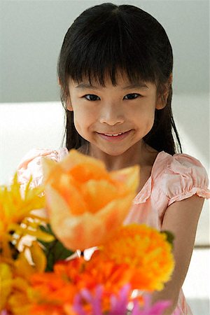Girl with flowers smiling at camera Stock Photo - Premium Royalty-Free, Code: 656-01828906