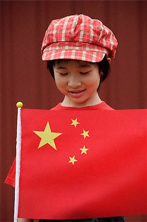 Portrait of little girl standing behind Chinese flag Stock Photo - Premium Royalty-Free, Code: 656-02371724