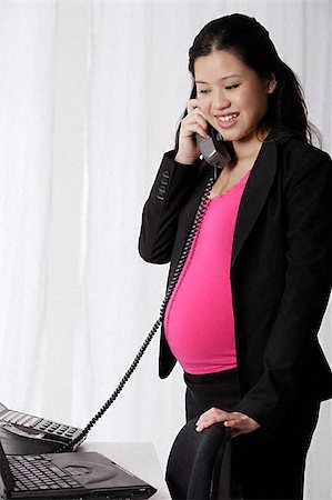 Profile of pregnant businesswoman on phone Stock Photo - Premium Royalty-Free, Code: 656-02371755