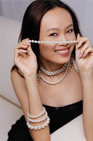 simsearch:655-02375891,k - Young woman holding strand of pearls Foto de stock - Royalty Free Premium, Número: 656-02371803