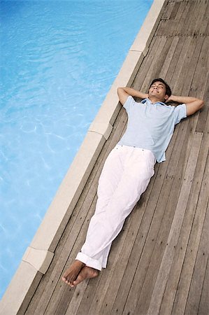 Man reclining by pool Stock Photo - Premium Royalty-Free, Code: 656-02371810