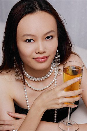 elegant pearl necklace - Young woman holding glass of champagne Stock Photo - Premium Royalty-Free, Code: 656-02371841