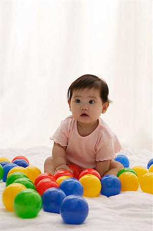 Baby girl playing with balls Stock Photo - Premium Royalty-Free, Code: 656-02660214