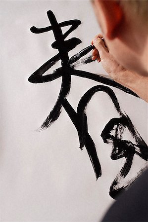 Man writing Chinese calligraphy, character for "Spring" Stock Photo - Premium Royalty-Free, Code: 656-02660228