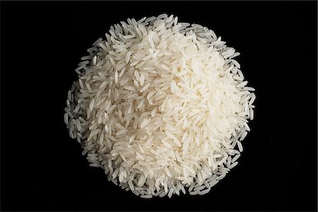 a pile of uncooked rice against a black plate Stock Photo - Premium Royalty-Free, Code: 656-02702782