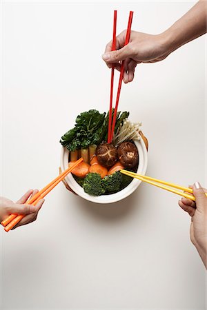 hands holding chopsticks in clay pot of vegetables Stock Photo - Premium Royalty-Free, Code: 656-02702804