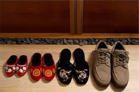 top view of slippers and shoes placed in a row at door front Stock Photo - Premium Royalty-Free, Code: 656-02702830