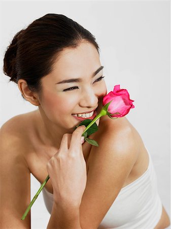 pink, rose, white background - woman smiling with rose Stock Photo - Premium Royalty-Free, Code: 656-02879455