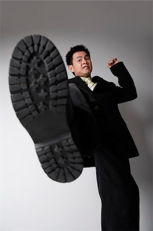 shoe worm eye view - business man ready to stomp Foto de stock - Sin royalties Premium, Código: 656-02879575