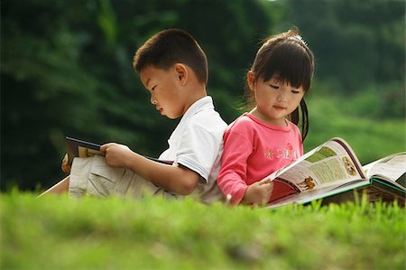 little boy and girl reading a book outdoors Stock Photo - Premium Royalty-Free, Code: 656-02879650